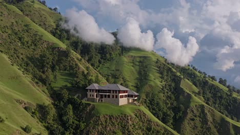 luxurious mountain lodge nestled on a lush hillside, surrounded by rolling green slopes and a breathtaking valley, under a dramatic cloudy sky