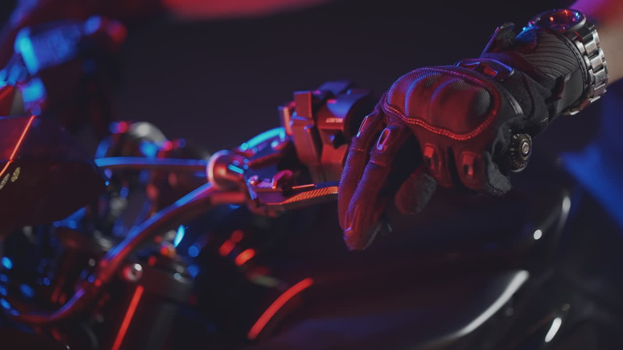 la mano del motociclista en los controles por la noche