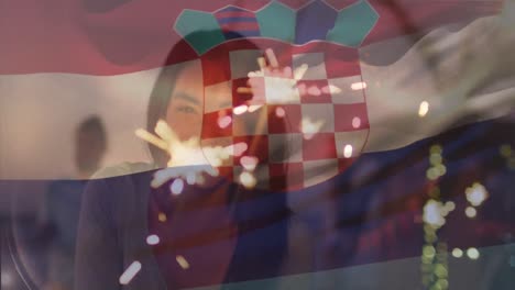 Animation-of-flag-of-croatia-over-happy-biracial-woman-with-fireworks