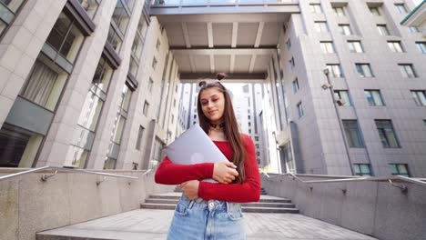 joven con una computadora portátil en las escaleras de la ciudad