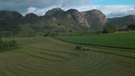 Volteador-De-Heno-Tirado-Por-Tractor-En-El-Trabajo-En-Prado-Verde-En-Rogaland,-Noruega