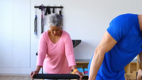 entrenador ayudando a las mujeres mayores en la realización de yoga 4k