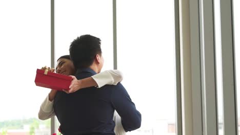 romantic couple giving gift to lover at restaurant