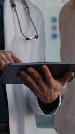 doctor explaining diagnosis to patient using tablet