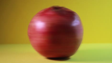 pomegranate in fast rotation on yellow background