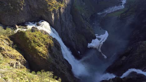 spectacular vøringsfossen waterfall in dramatic landscape hardangervidda norway - static shot of waterfall during beautiful sunset with water spashing far down in the canyon