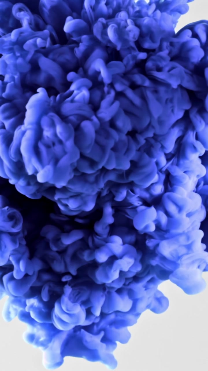Inchiostro blu vivace che si diffonde nell'acqua con sfondo bianco