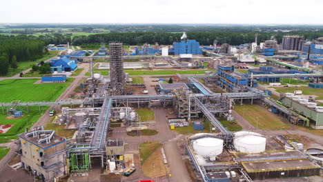 vista aérea de la planta petroquímica con molinos de viento en el fondo