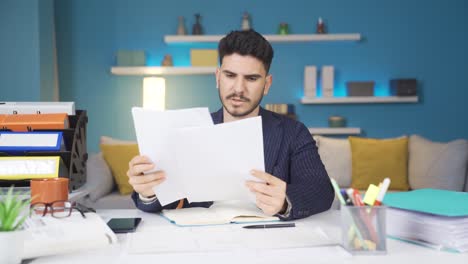 el trabajador de la oficina en casa que mira los documentos es feliz.