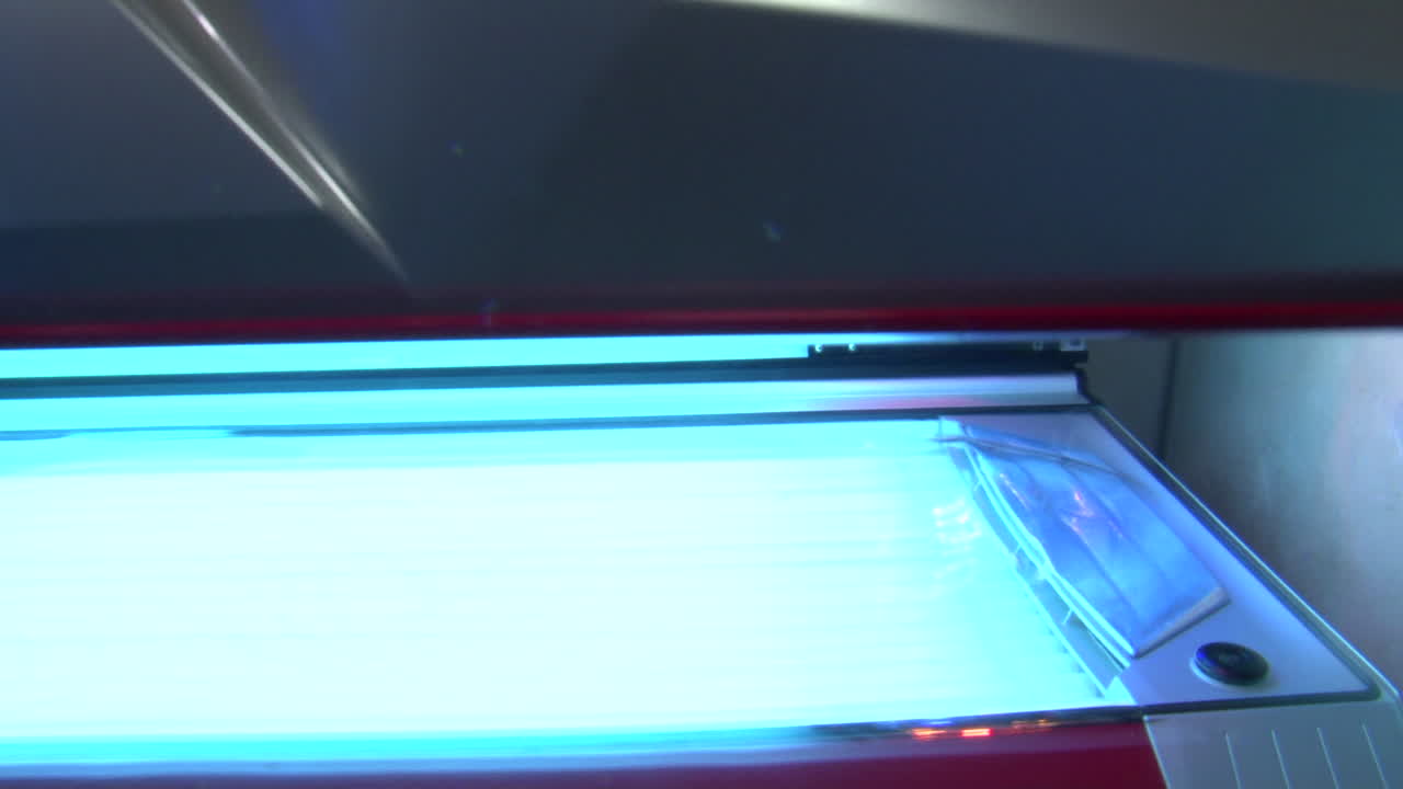 Close up shot of silver sunbed lid being opened and closed while switched on