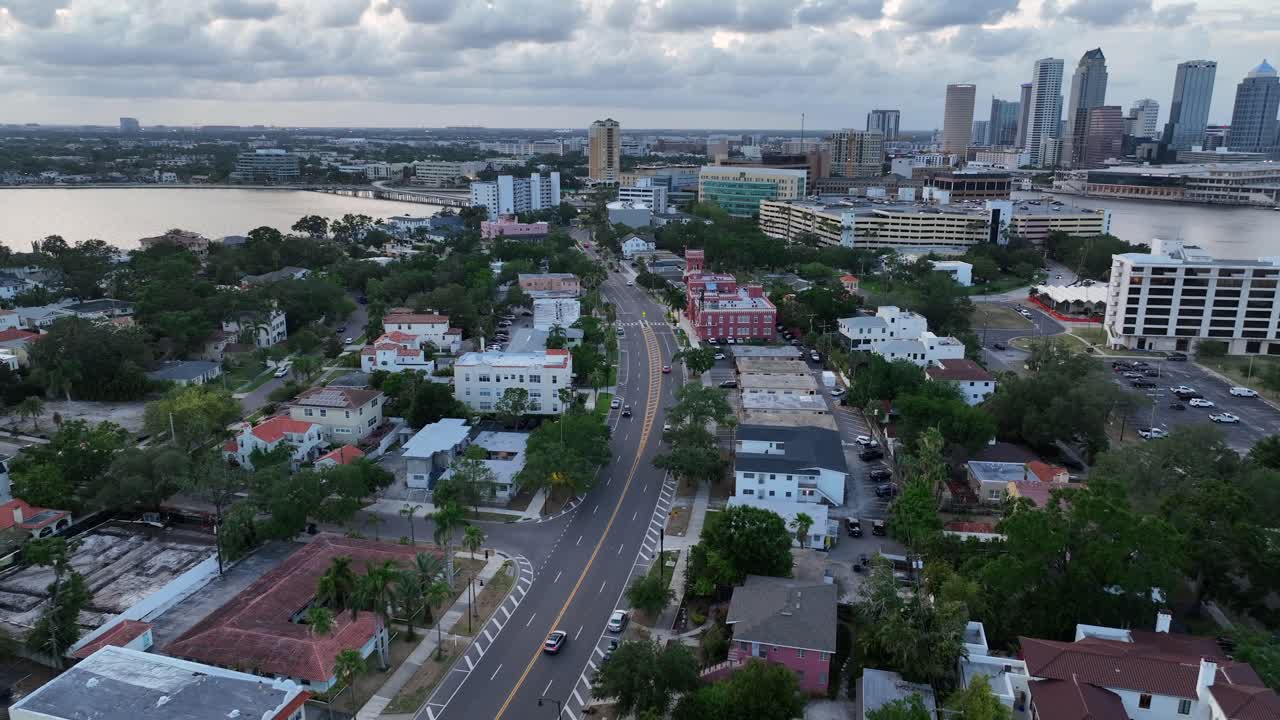 Traffic scene on road at bayshore of Tampa city at dusk. Aerial wide shot. Downtown skyline with Skyscrapers in distance. Florida, USA.