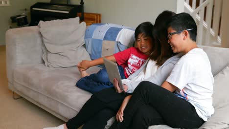 mother and sons using digital tablet in living room 4k