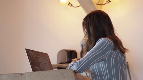 woman focused on laptop in cozy workspace, warm beige tones, symbol of productivity and modern remote work lifestyle