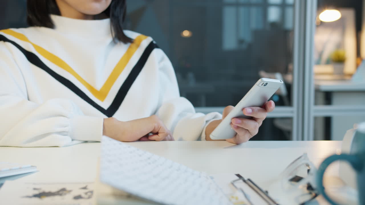 사무실에서 스마트폰을 사용하는 여성