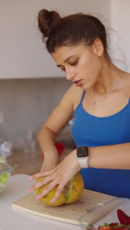 woman preparing a fruit salad with cantaloupe and strawberries