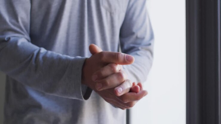 Busto di un uomo caucasico che si strofina le mani con gel igienizzante al rallentatore