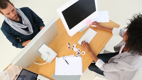 equipo de diseño trabajando en un escritorio y sonriendo a la cámara