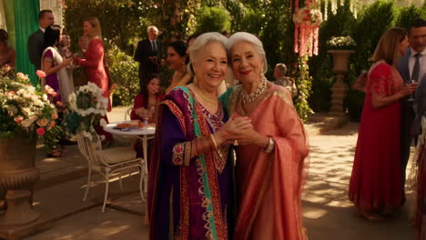 two happy older women dancing at a celebratory outdoor event, possibly a wedding