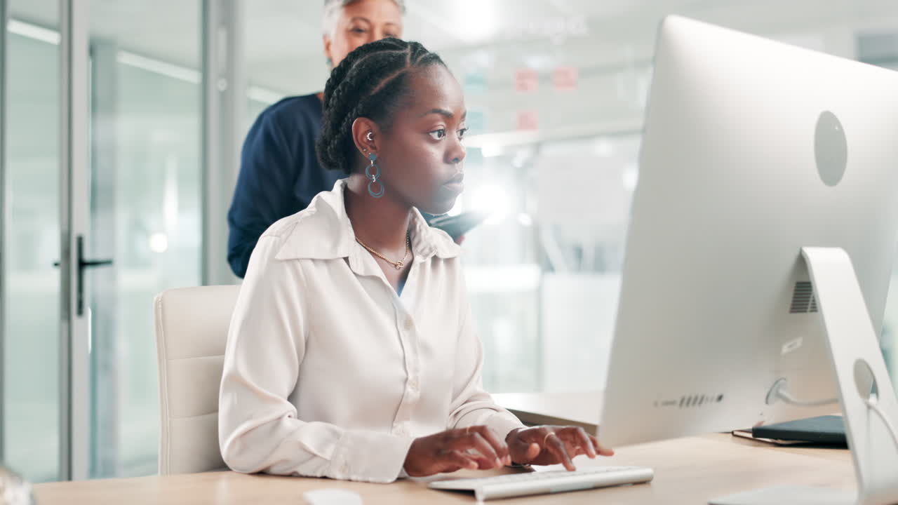 dos mujeres de negocios colaborando en una computadora