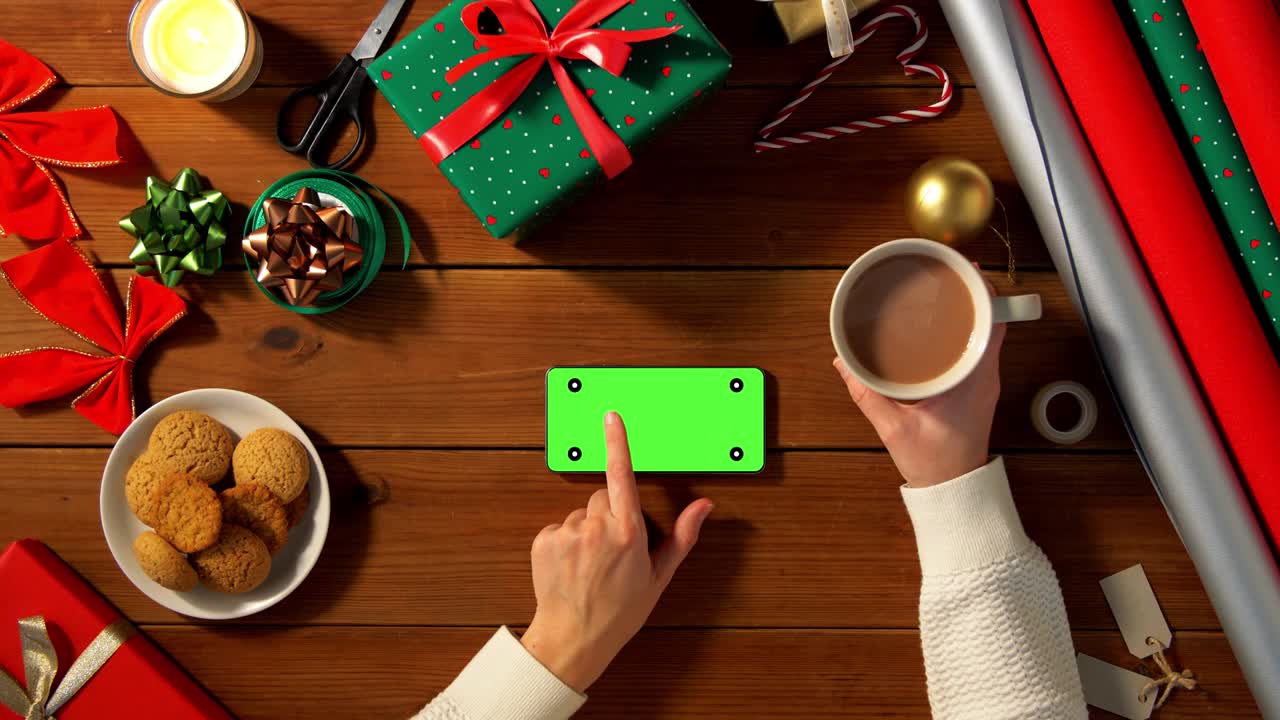 mujer con teléfono inteligente y café en navidad