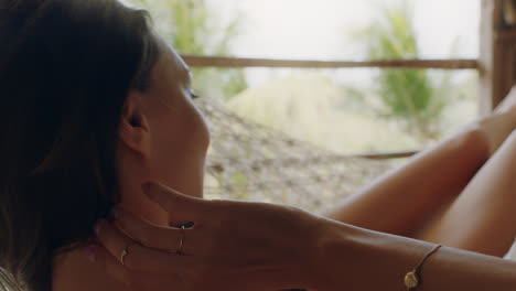 mujer feliz en una hamaca disfrutando de un estilo de vida cómodo de vacaciones en un complejo vacacional balanceándose pacíficamente en un perezoso día de verano en una cabaña de paraíso tropical