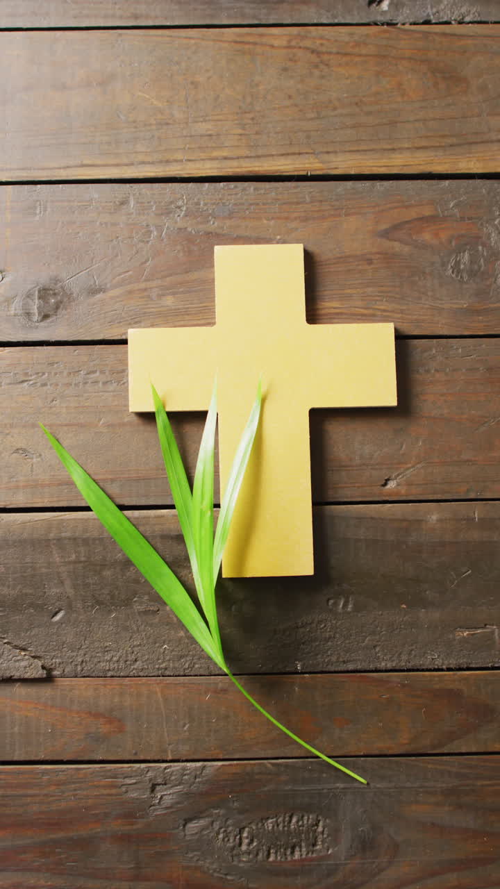 Video verticale di foglie di palma della Domenica delle Palme e croce cristiana gialla su assi di legno con spazio per il testo