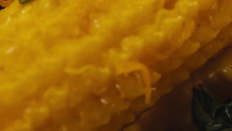 close-up of fermented yellow mini corn with black pepper on plate. preservation of vegetables in glass jars. fermentation preserved mini corns with spices macro.
