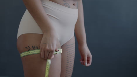 woman measuring her thighs