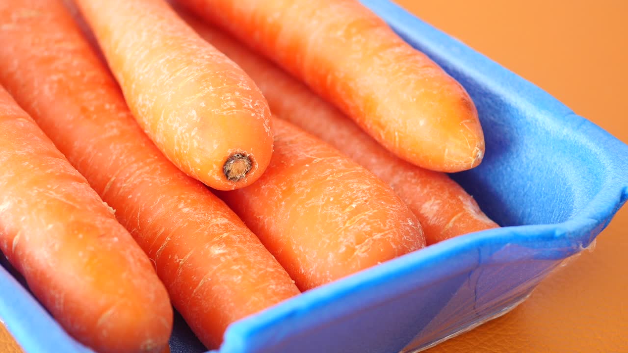 Primer plano de zanahorias frescas en un recipiente azul