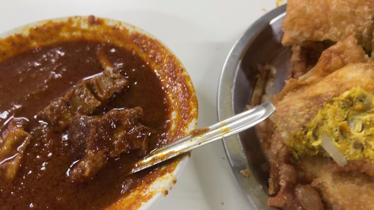 Close up shot of Mughlai paratha and mutton kossa served in a Bengali restaurant.