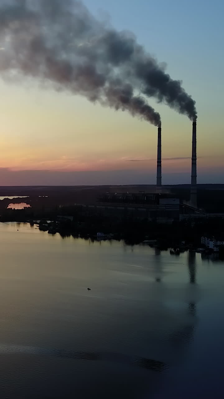 Smoke From The Pipe Factory Near The River. Landscape of an industrial estate with pipe factory smoke near river Vertical video