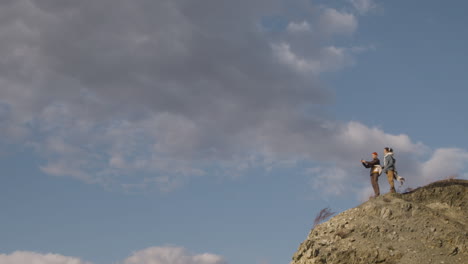 Far-View-Of-Two-Teenage-Boys-In-Winter-Clothes-On-Top-Of-A-Mountain-On-A-Windy-Day-1