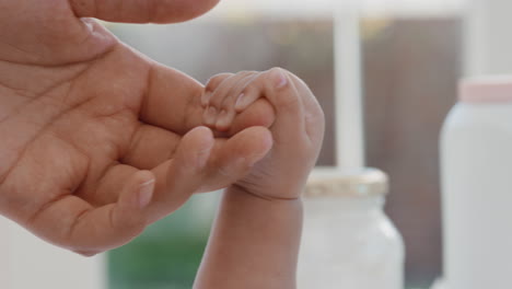 close up mother holding baby hand touching fingers mom nurturing newborn caring for infant at home motherhood love 4k