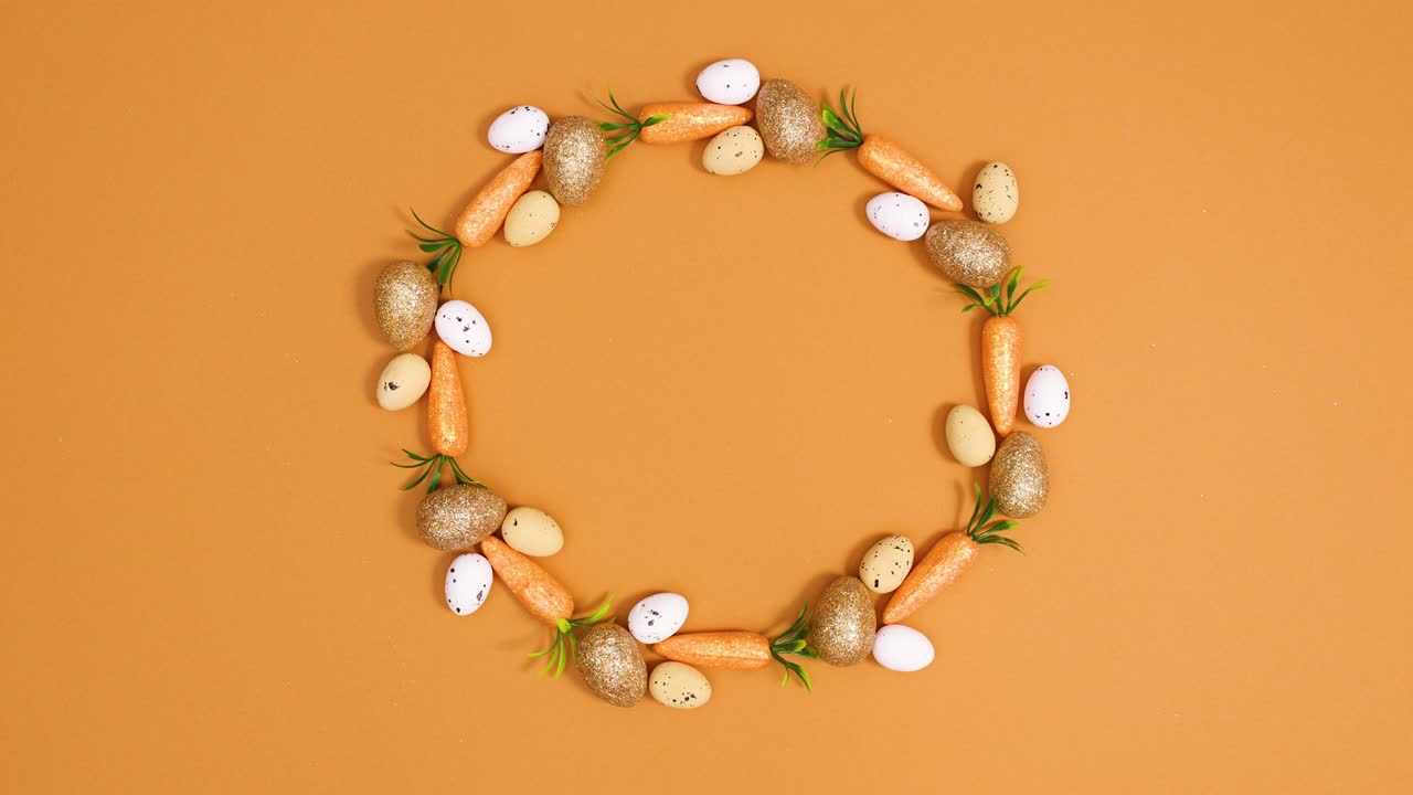 Easter creative copy space circle made of eggs and carrots on orange background. Stop motion