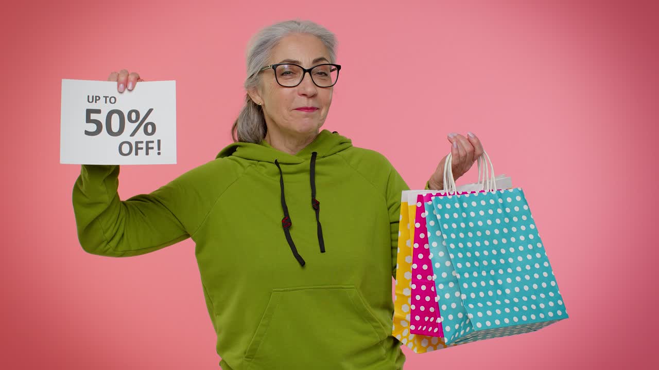 abuela mayor mostrando bolsas de compras y hasta un 50 por ciento de descuento en inscripciones pancarta, viernes negro