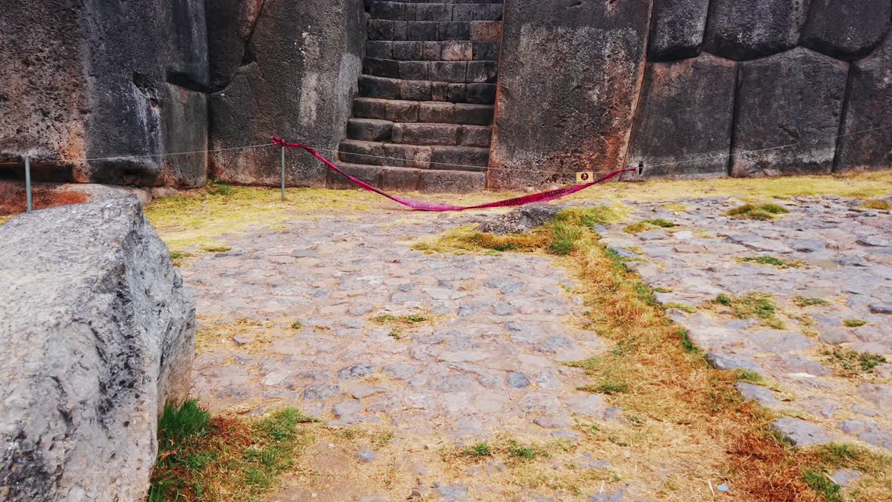 Tilt up reveal shot of famous stairway at Sacsayhuamán archaeological site in Cusco, Peru