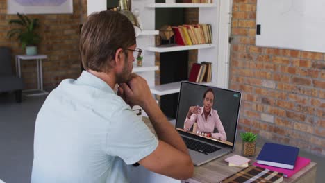 estudiante caucásico usando una computadora portátil en una videollamada con una maestra