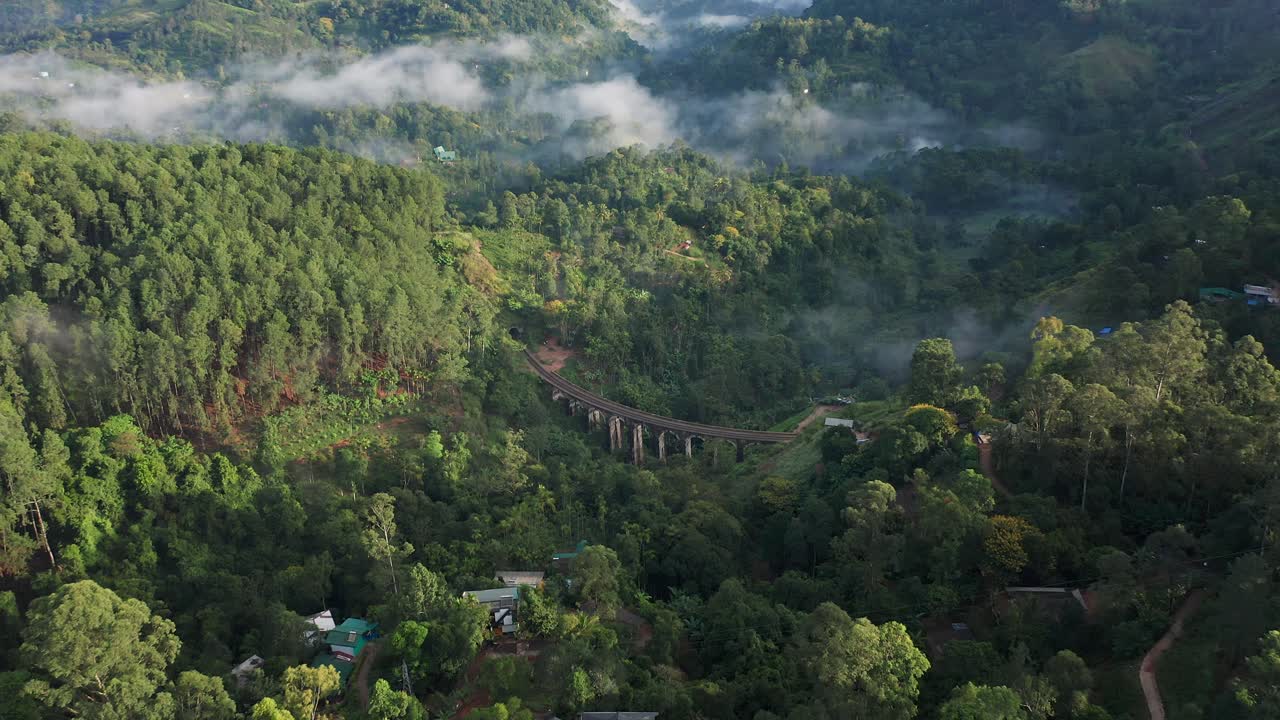 Splendida e unica veduta aerea del Ponte a Nove Archi, circondato da una giungla lussureggiante e nuvole basse, Ella, Sri Lanka