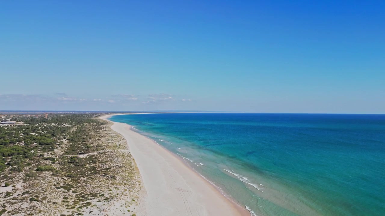 Spiaggia incontaminata e deserta di sabbia bianca e oceano turchese a Comporta, vicino a Lisbona, Portogallo. Perfetto per concetti di viaggio, vacanza ed estate, viste aeree.