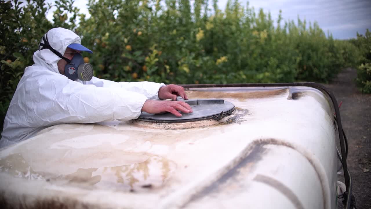 Farmer spray insecticide, pesticide, pesticides or insecticides spraying on lemon trees agricultural field in Spain