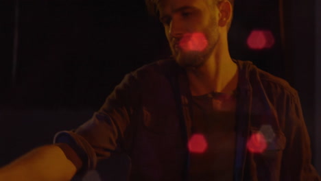 man analyzing technology data in dimly lit scene, with animated chart floating amidst red bokeh