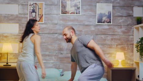 cheerful husband and wife wearing pajamas