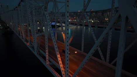 Antena-Ascendente-Del-Horizonte-De-Nueva-Orleans-Por-La-Noche-Desde-La-Vista-Del-Puente-Con-Luces