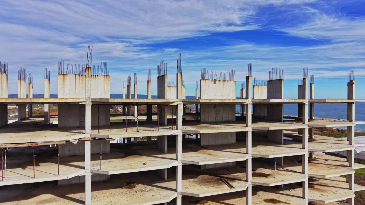 Construction site near coastline shows unfinished building in daylight
