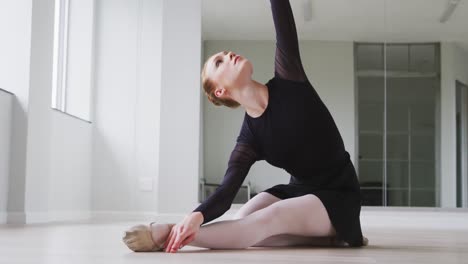 caucasian female ballet dancer practicing a dance routine during a ballet class