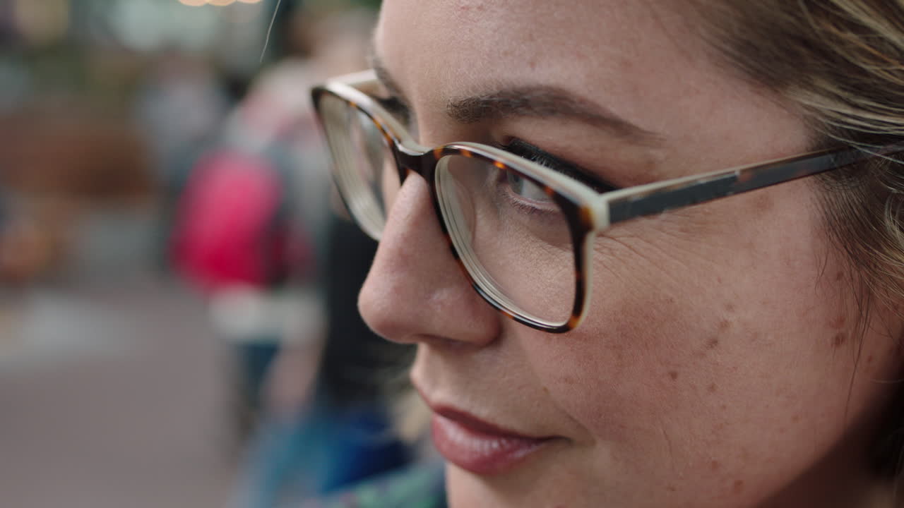 retrato de cerca de una hermosa mujer rubia mirando fijamente mirando serio contemplativo corriendo mano a través del cabello con gafas trasfondo urbano