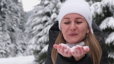 beautiful girl shakes the snow from a tree branch she is happy and smiling playing with snow beautiful girl shakes the snow from a tree branch she is happy and smiling playing with snow new years mood in women
