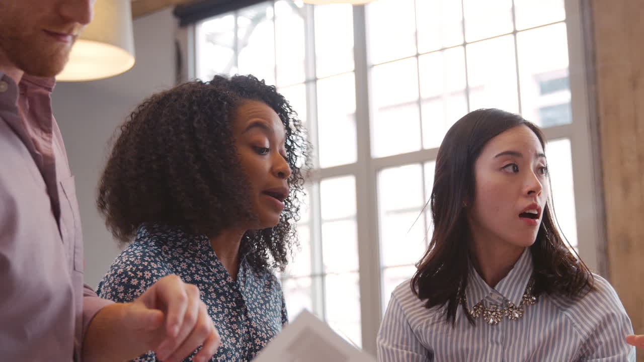tres jóvenes creativos discutiendo ideas en el trabajo, de cerca
