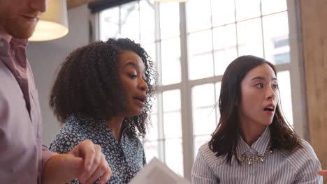 three young creatives brainstorming ideas at work, close up