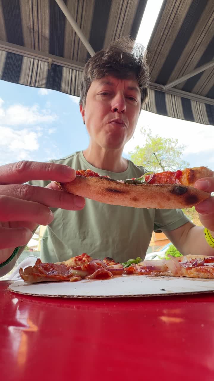 persona comiendo pizza al aire libre